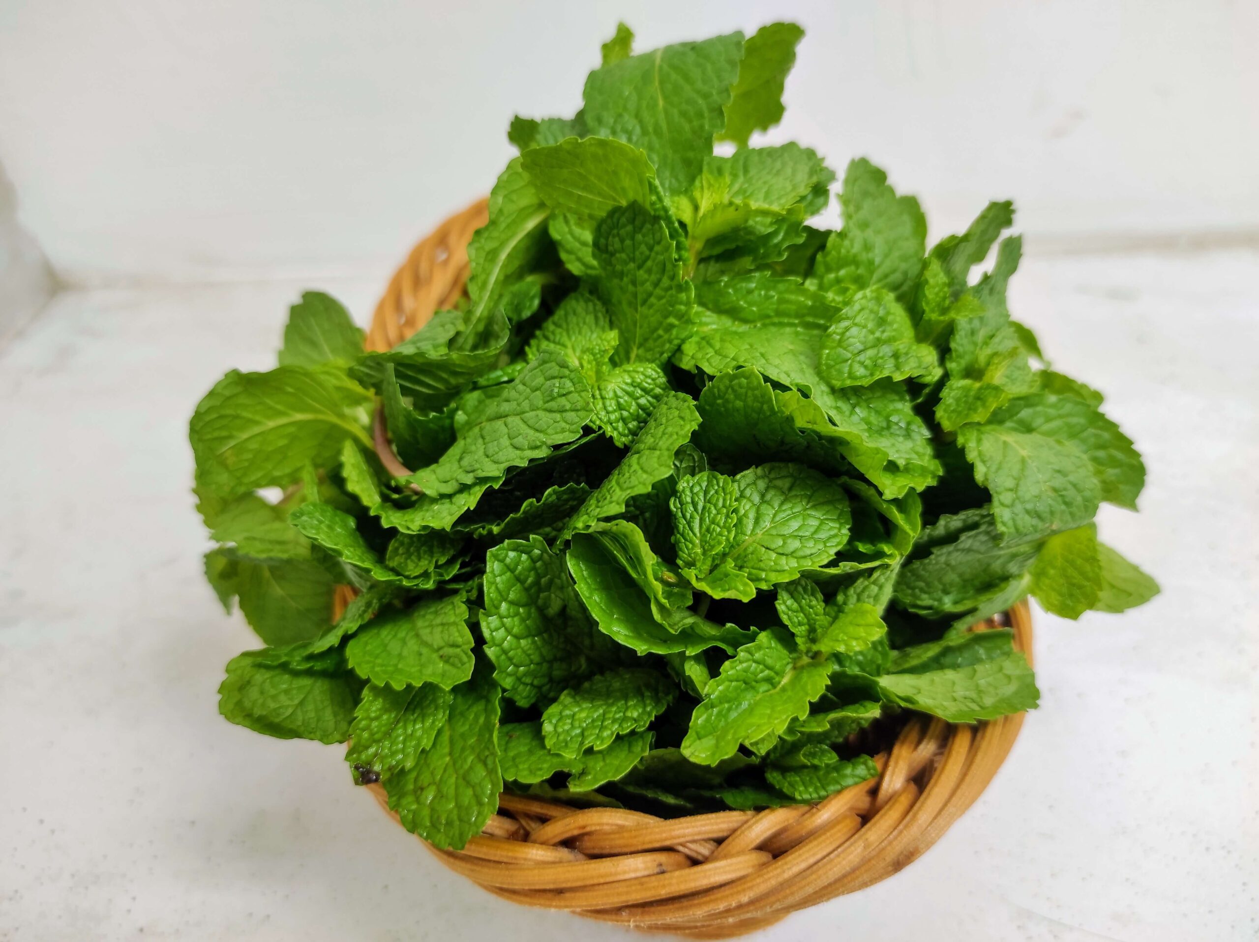 a bundle of fresh mint in a small woven basket