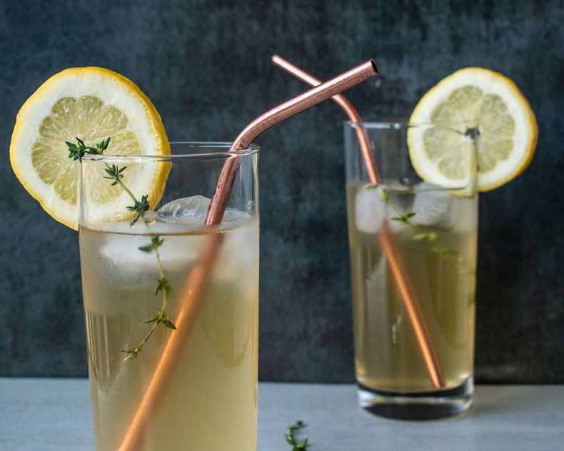 Refreshing Amish Meadow Tea with lemon slice in a glass cup with copper straw