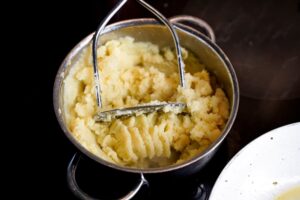 A person mashes boiled potatoes to make PA Dutch potato filling.