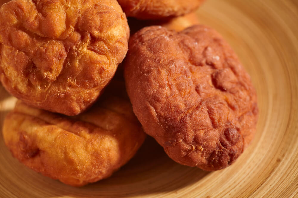 pile of amish Fasnachts sitting on a wooden plate